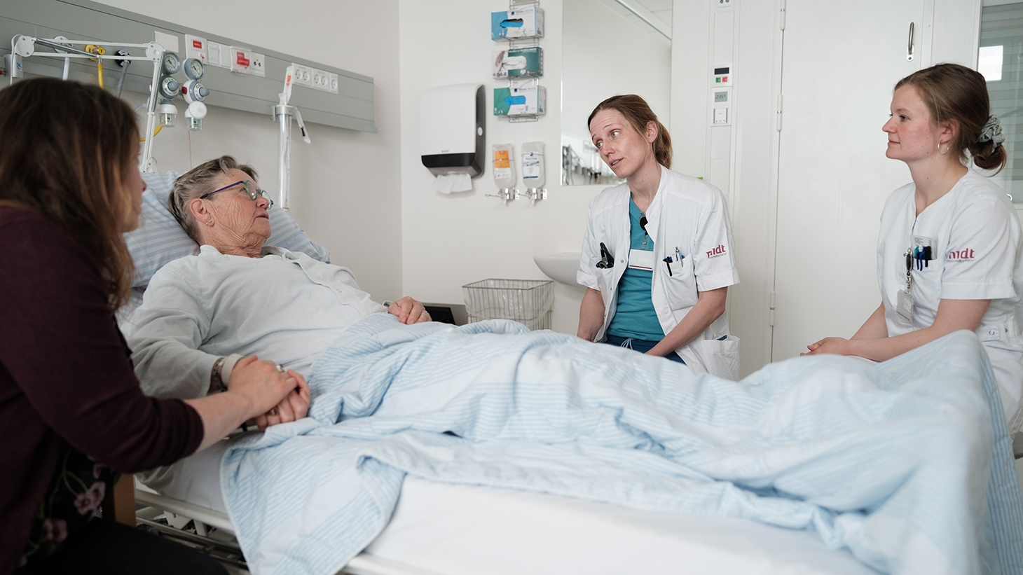 Patient taler med læge under stuegang på sengeafsnit
