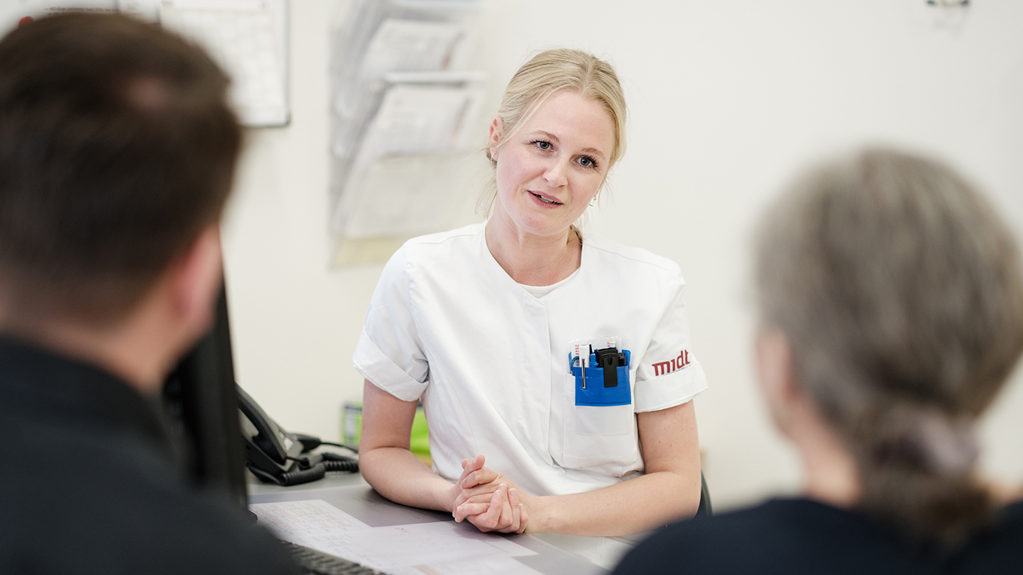 Patient og pårørende taler med sygeplejerske i klinikken