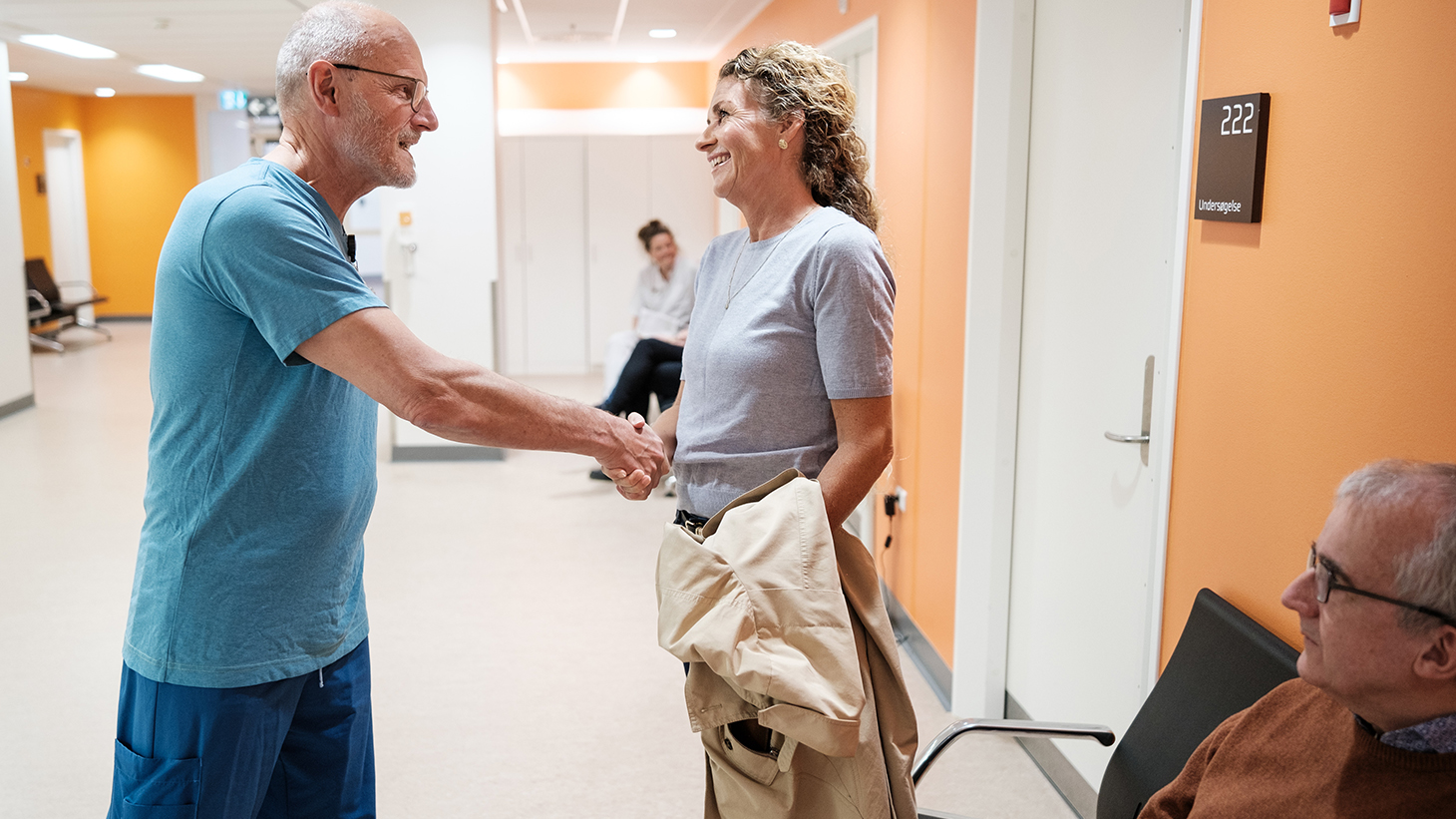 Læge byder patient vekommen i klinik