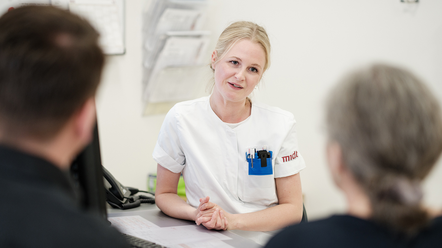 Sygeplejerske taler med patient i konsultationen