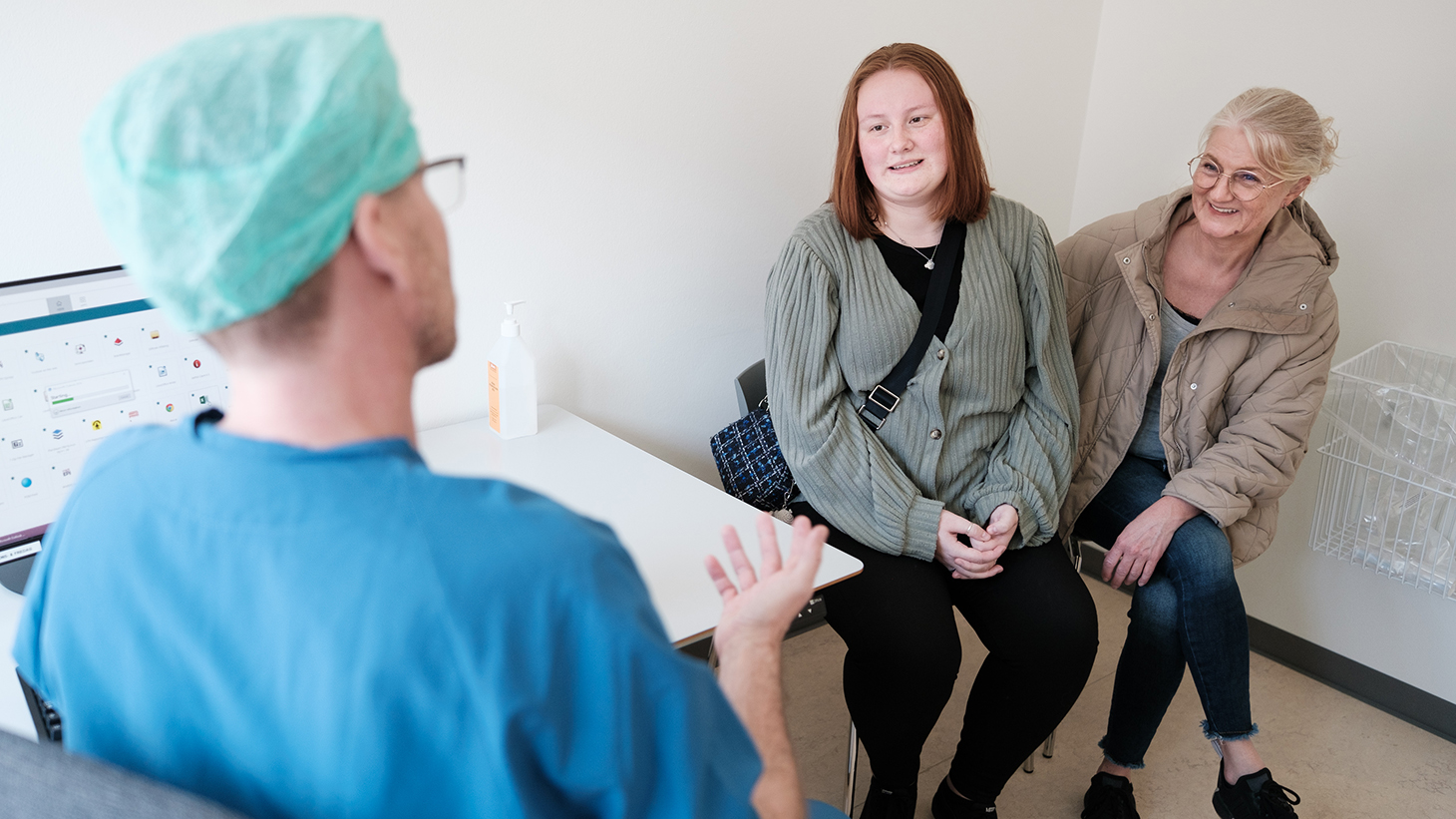 Læge taler med patient og pårørende i bedøvelsesklinikken